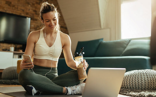 Woman Sitting With Protein Shake And Laptop
