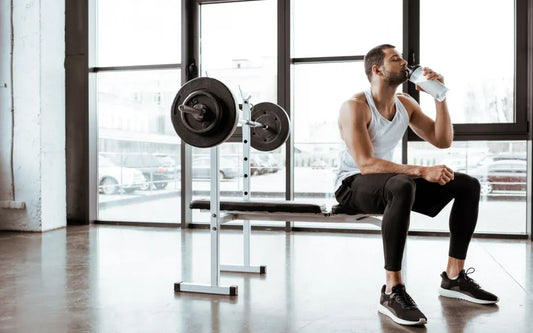 person drinking intra workout supplement in gym