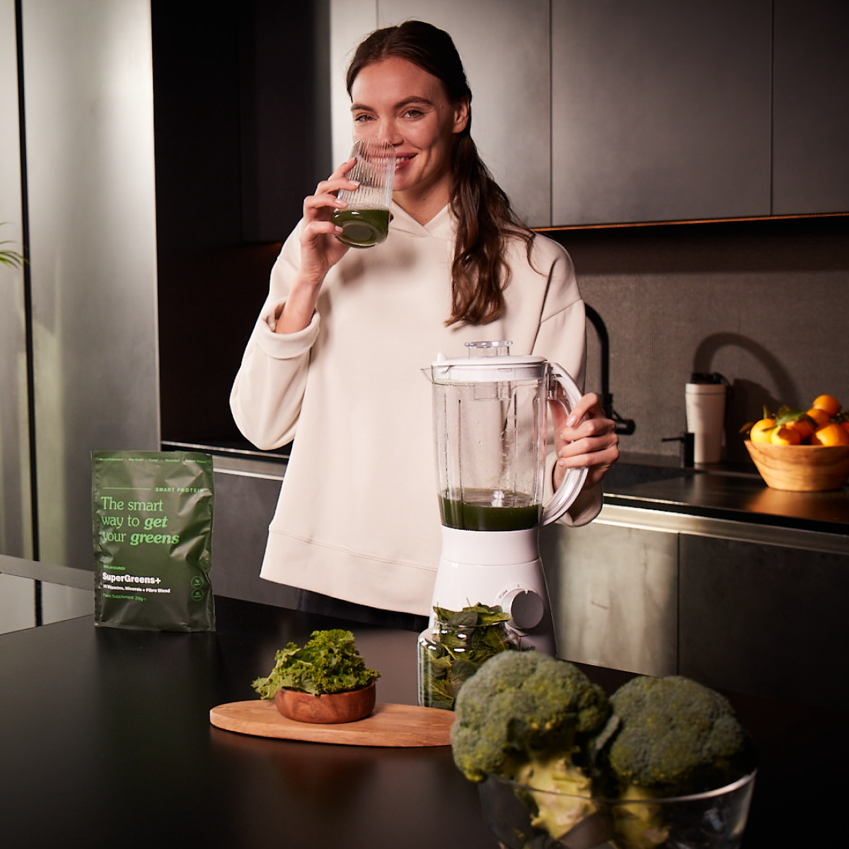 SuperGreens Food Supplement and Lady With Blender